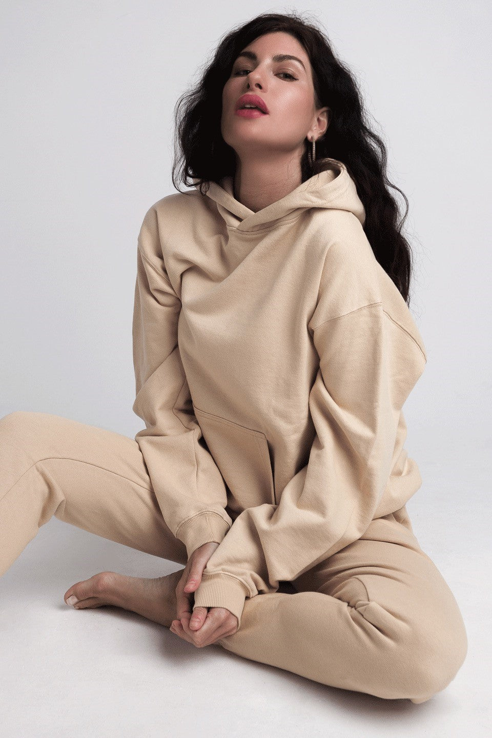 Organic Hoody - Sand on model with matching joggers and leg crossed